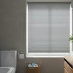 Baño con persianas plisadas grises